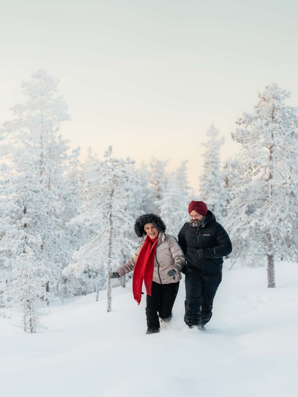 Couple walking in a snowy Lapland winter forest, romantic couple photoshoot in Finnish Lapland